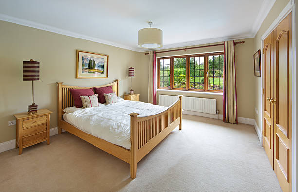 Wooden bed frame in a large bed room.