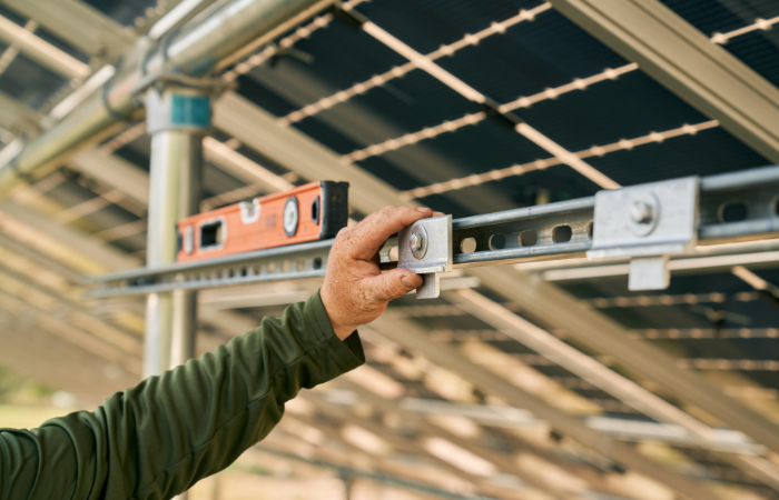 A person skillfully attaches a bolt to a solar panel.