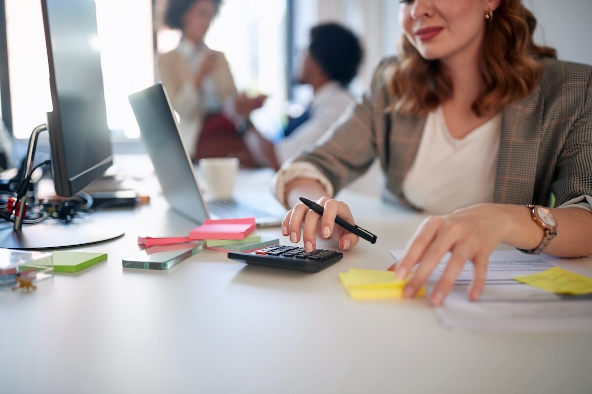 Manager using a calculator while holding a pen