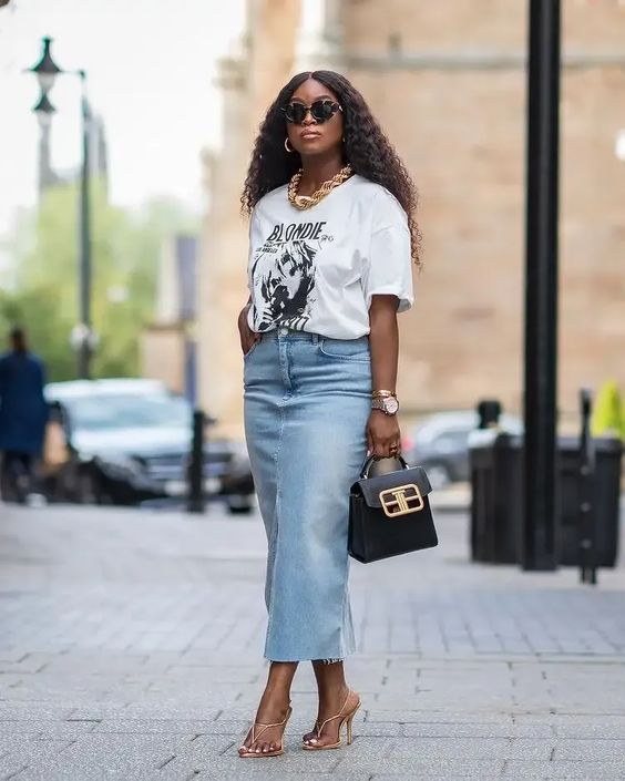 Picture of a lady rocking  the long denim skirt with cute bags to match