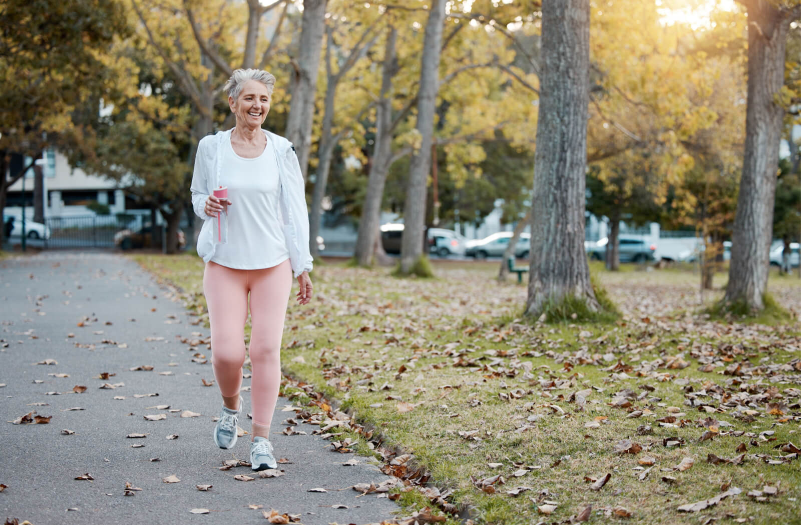 A senior woman in active wear taking an early morning walk as a part of her routine.