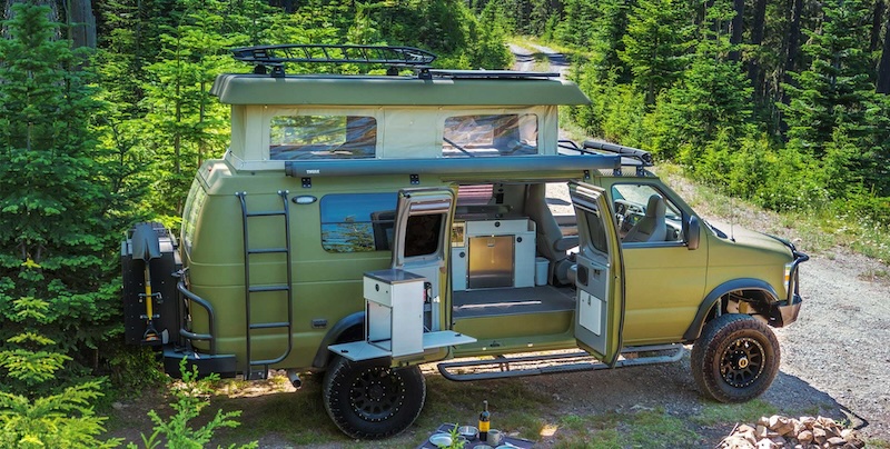 Green Sportsmobile camper van in the woods