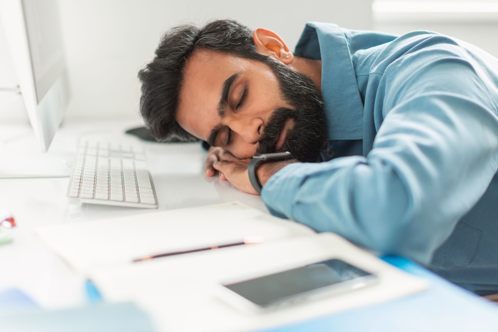 Man sleeping at computer during downtime of business server upgrade
