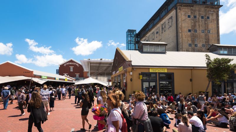 A bustling scene at the Woodstock neighborhood in Cape Town, known for its vibrant street markets and artistic atmosphere.