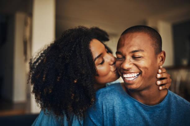 You're simply the best, babe Shot of an affectionate young couple relaxing at home black lovers stock pictures, royalty-free photos & images
