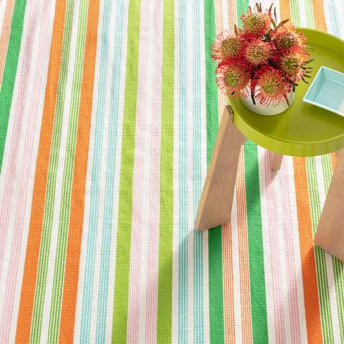 Orange, green, blue, and pink striped rug with a small green end table.