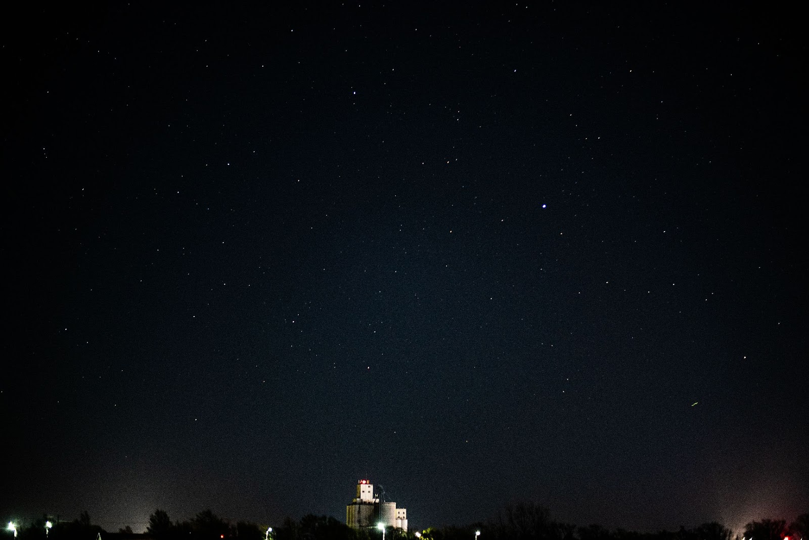 Photo of night sky and an illuminated grain elevator 