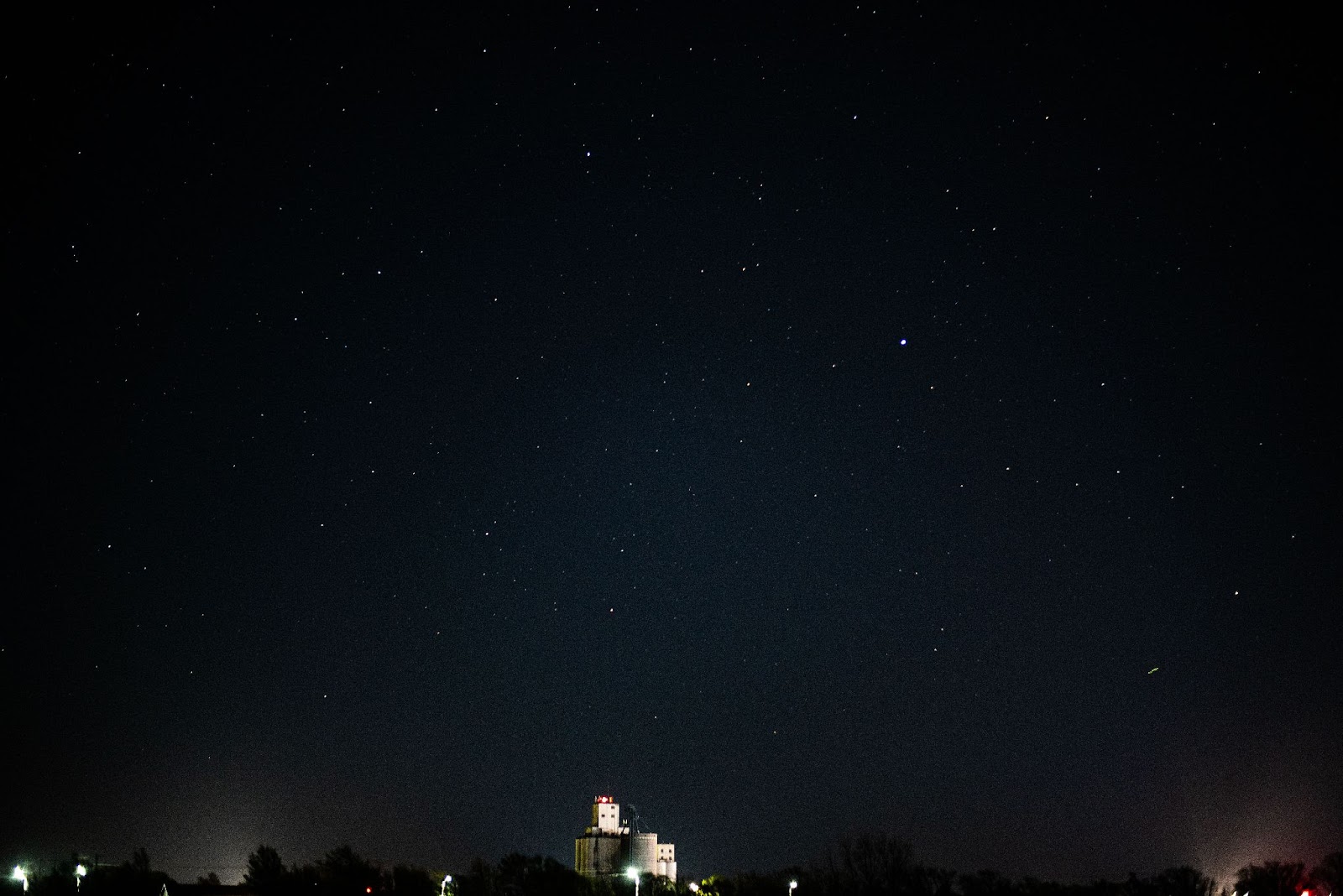 Photo of night sky and an illuminated grain elevator 