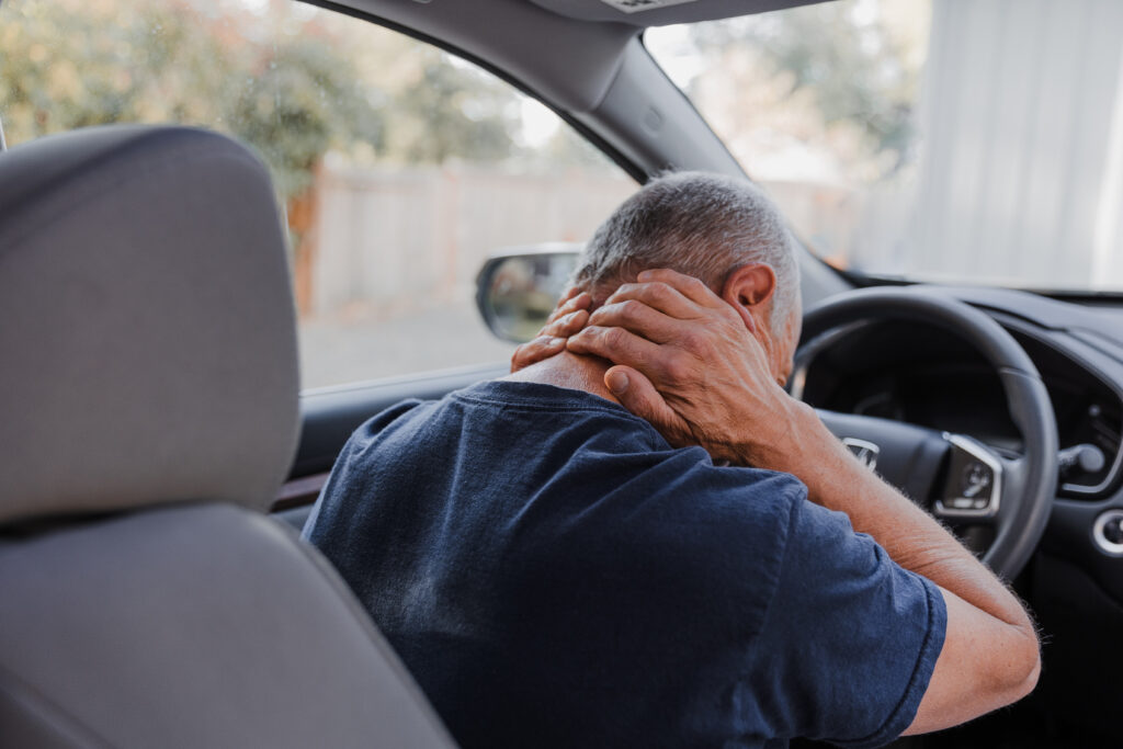 man in a car accident with injuries holding his neck