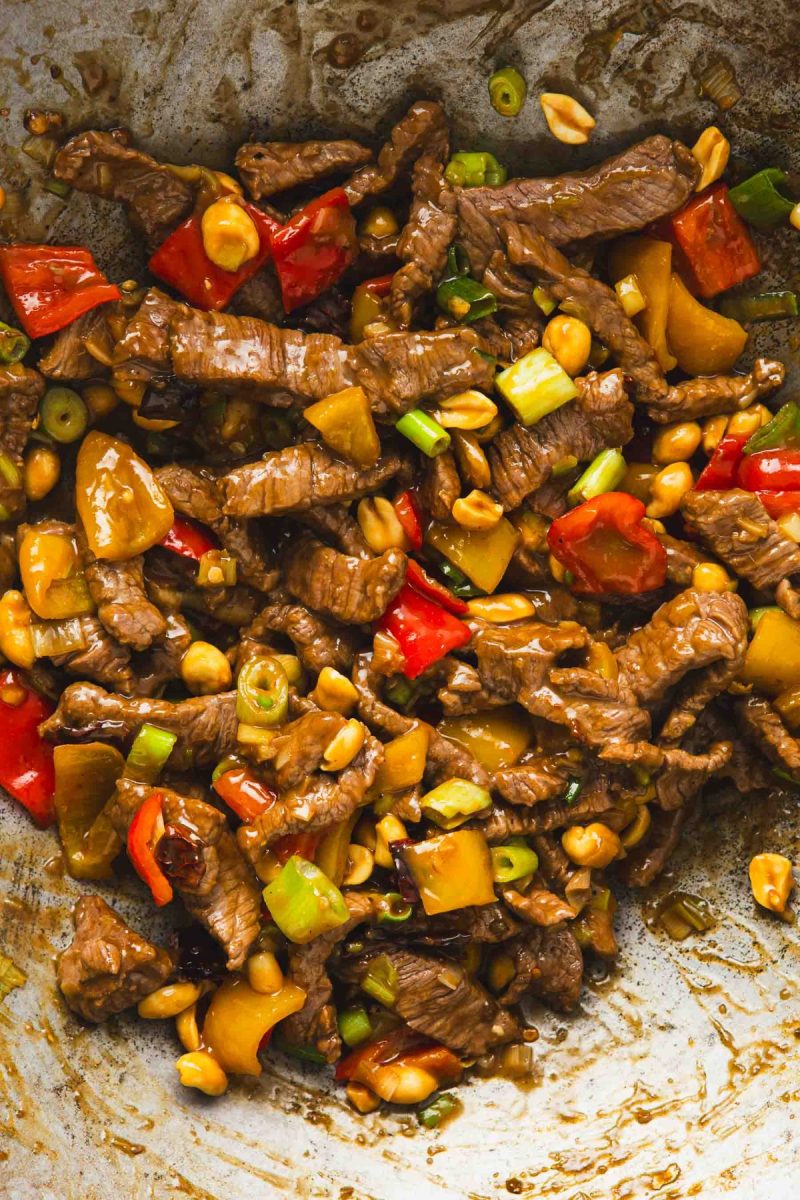 Kung Pao beef stir fry with peppers and peanuts in a wok.