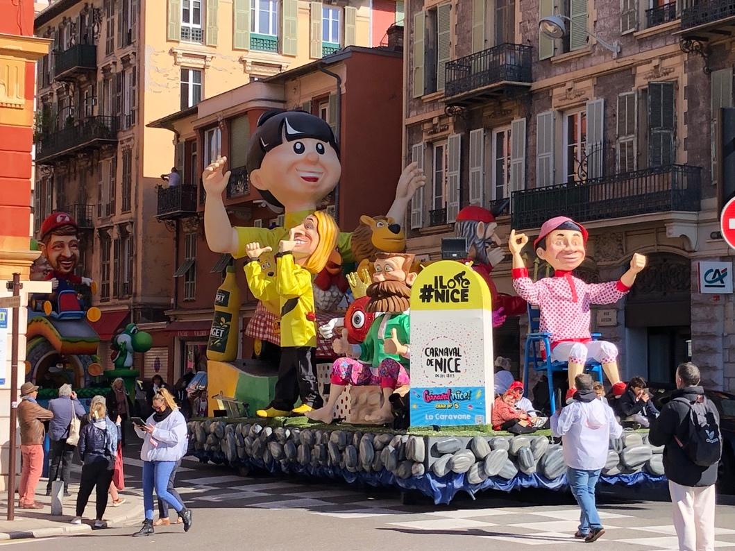 A float with people walking in the street

Description automatically generated
