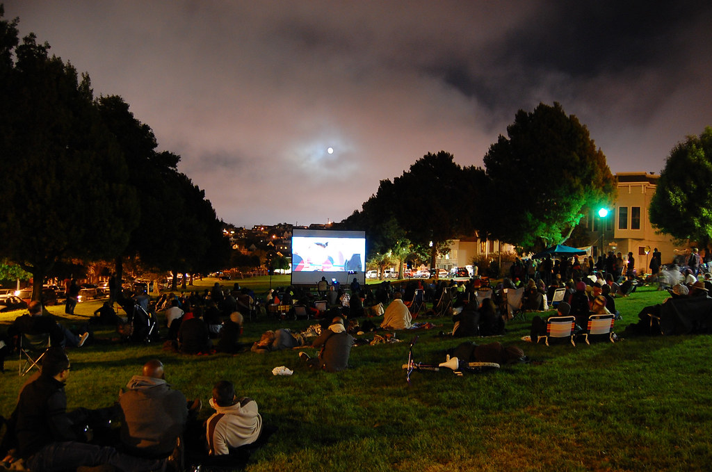 People enjoying outdoor movie night. 