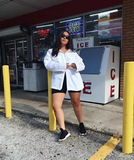 Picture showing a lady rocking white shirt and a biker shorts paired with sneakers