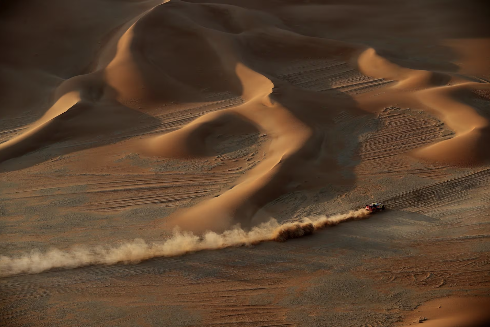 Picture of a car racing aross the desert.