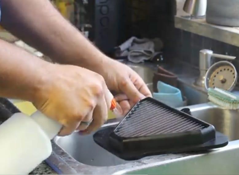  Spraying air filter with soapy water.