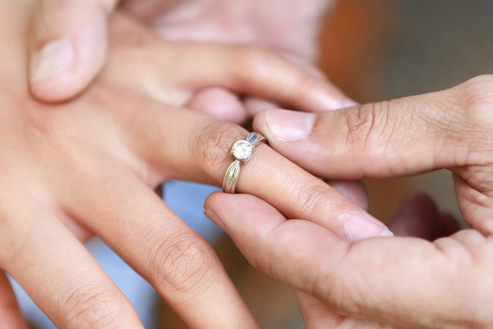 Picture showing man holding out a wedding band in his hand