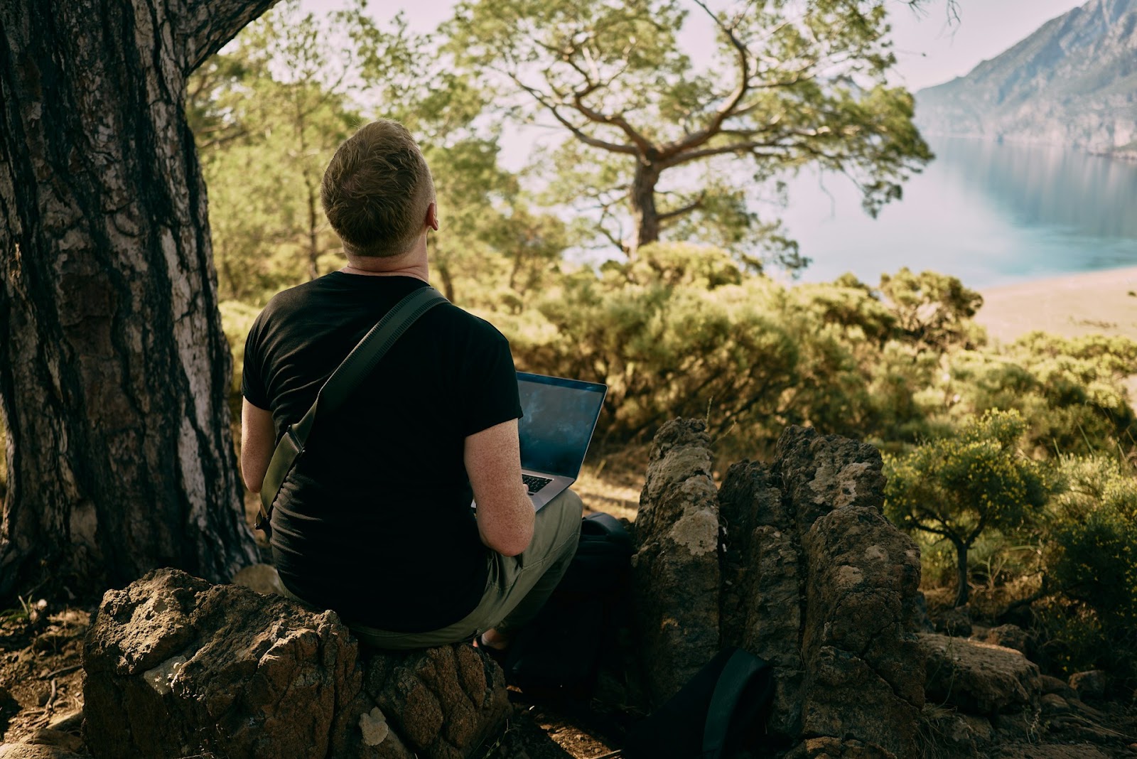 a man working on a laptop in nature