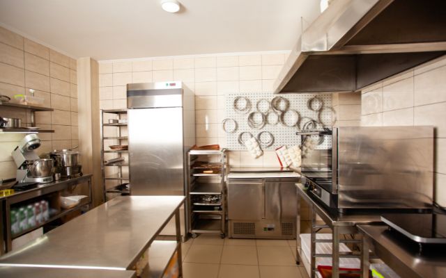 A clean and organized commercial kitchen with different kinds of cooking equipment..