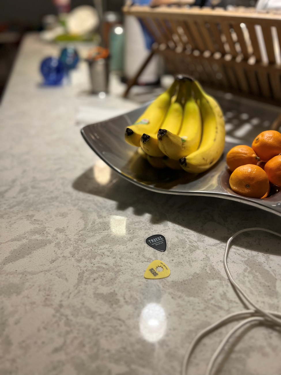 a "still life" comprised of some bananas, a couple guitar picks, and an out-of-focus dishrack, among other kitchen effluvia