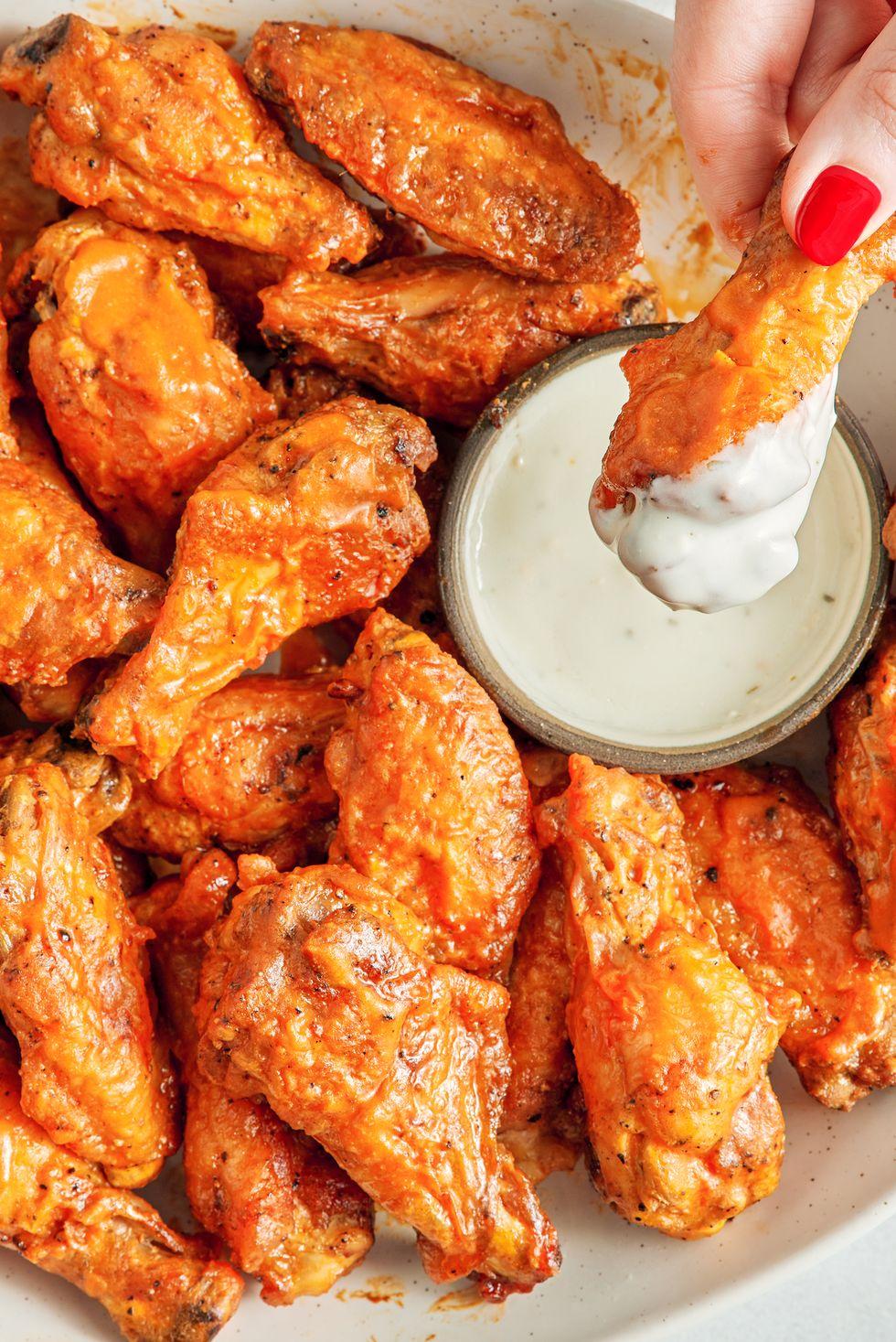 air fryer chicken wings covered in buffalo sauce with blue cheese and celery