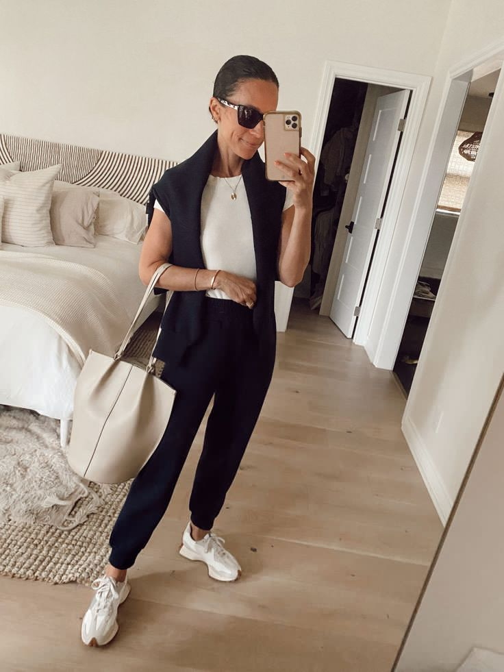Picture of a lady accessorizing her look with a chic sunglass while posing for a mirror selfie