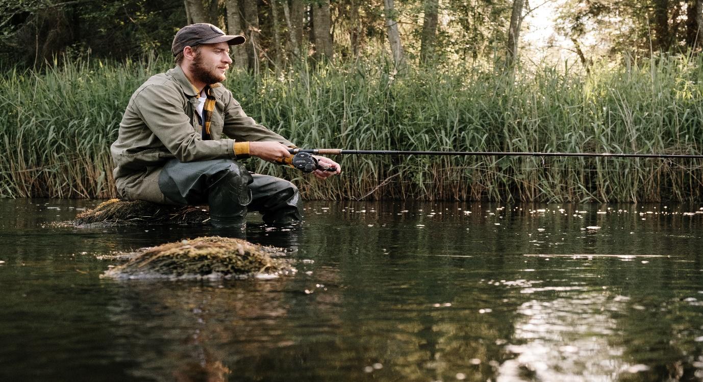 A person fishing in a river

Description automatically generated