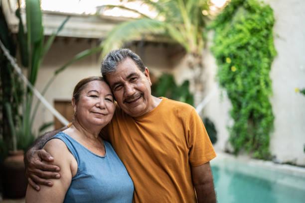 Portrait of mature couple embracing by the pool Portrait of mature couple embracing by the pool husband wife stock pictures, royalty-free photos & images