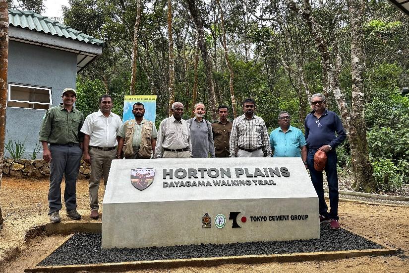 A group of men standing in front of a sign

Description automatically generated