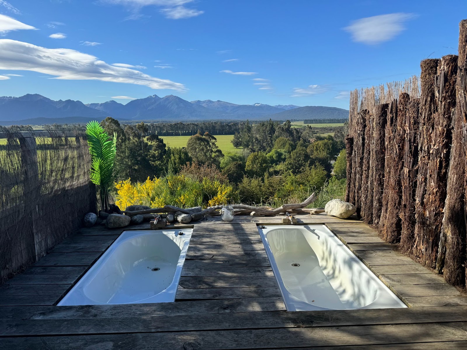 Two private bathtubs with a spectacular view of a meadow and mountains in New Zealand