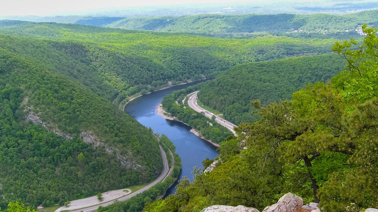 A winding road through a valley</p>
<p>Description automatically generated