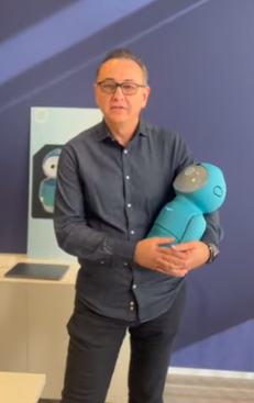 A picture of Embodied CEO Paolo Pirjanian holding Moxie like a baby