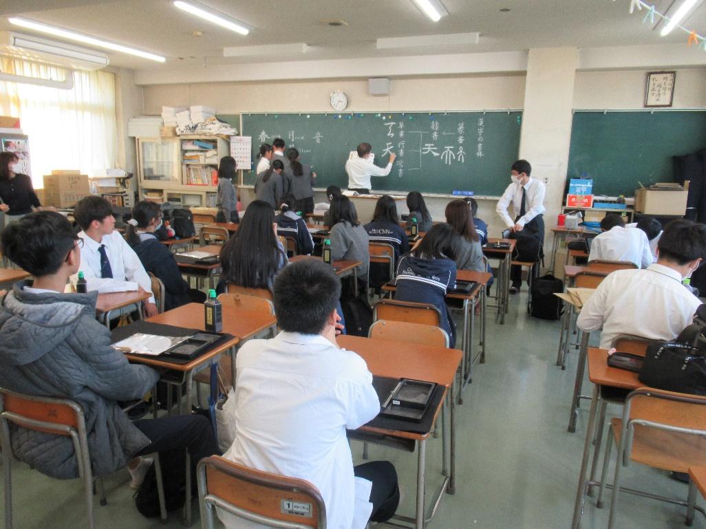 A classroom with students in front of a blackboard

Description automatically generated