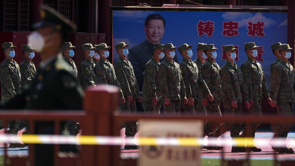 中国人民解放军（PLA）士兵在中国共产党第二十次全国代表大会开幕式期间，从一幅描绘中国国家主席习近平的海报前走过。2022年10月16日星期日北京