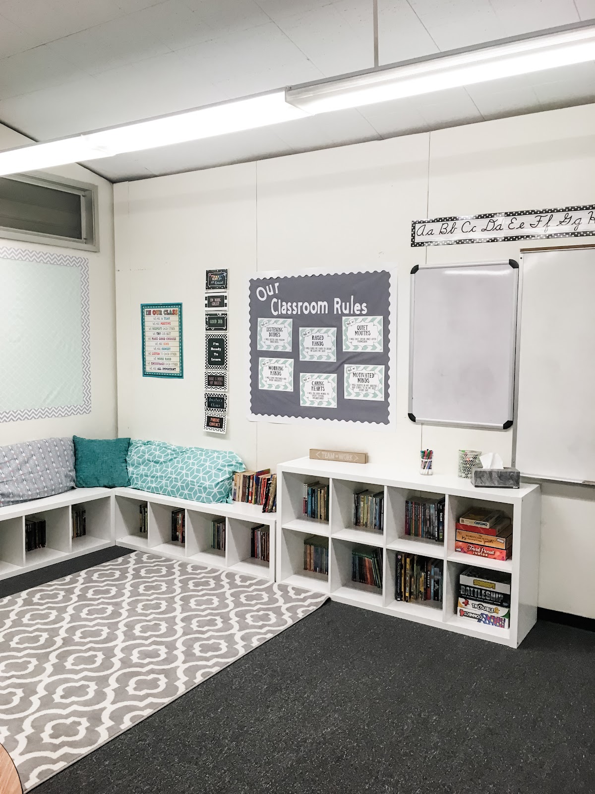 This image shows a classroom library with low bookshelves and pillows. 