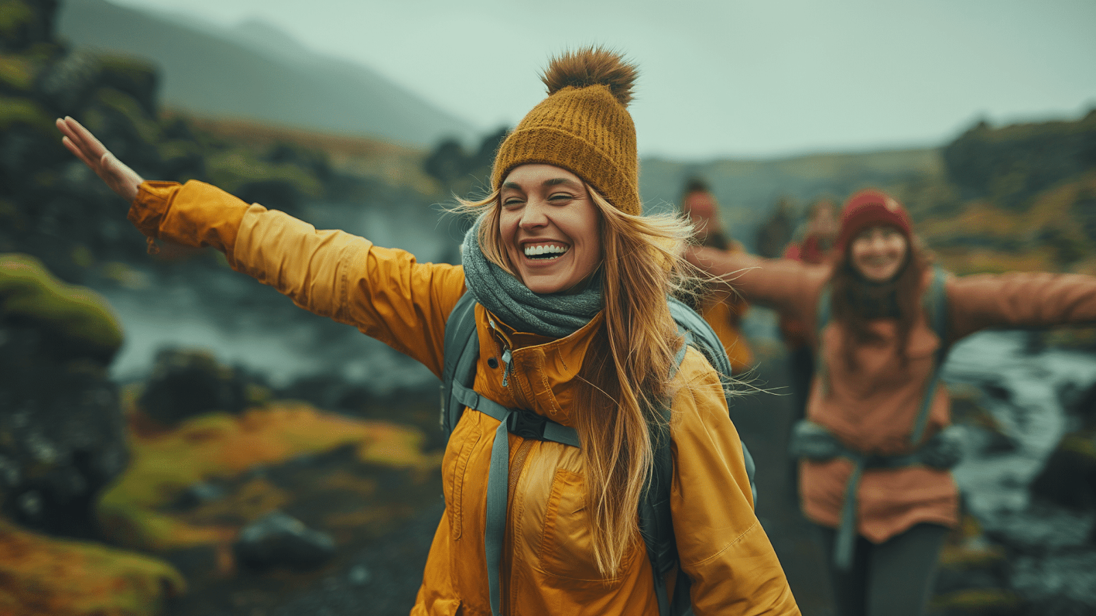 Woman in yellow jacket, arms wide, feeling the freedom  in Icelandic nature