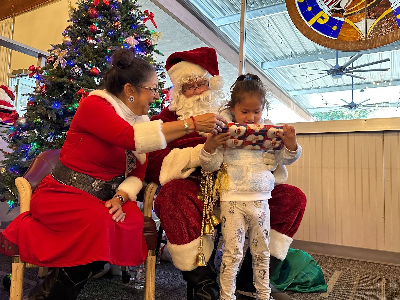 Santa Claus, Mrs. Claus, and a Girl on Santa's Lap.
