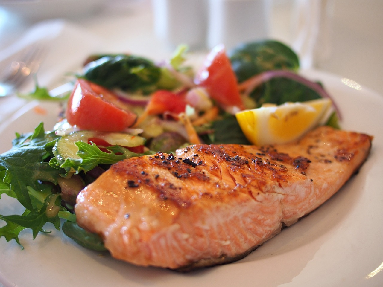 Приготоване філе лосося з салатом на тарілці - здорова їжа, яку можна їсти на дієті з інтервальним постом