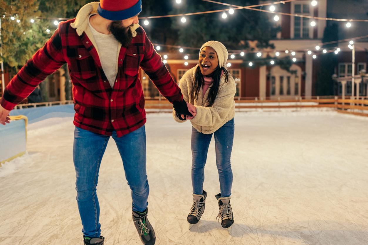 Close-up shot of a young couple ice skating with each other.
