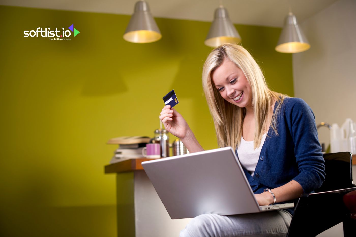 a woman smiling while holding her card and laptop