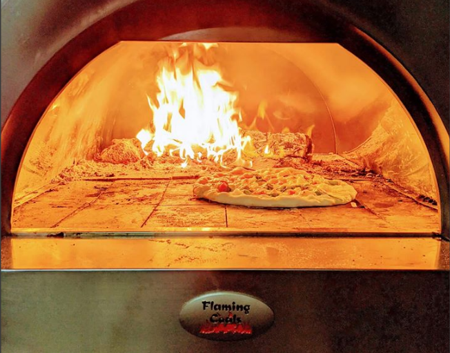 This_image_pizzas_being_cooked_on_the_Woodfired_pizza_oven