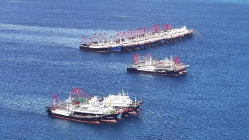 In this handout photo provided by the Philippine Coast Guard, suspected Chinese militia ships stay near the Philippine-claimed reef called Whitsun, locally known as Julian Felipe reef, at the disputed