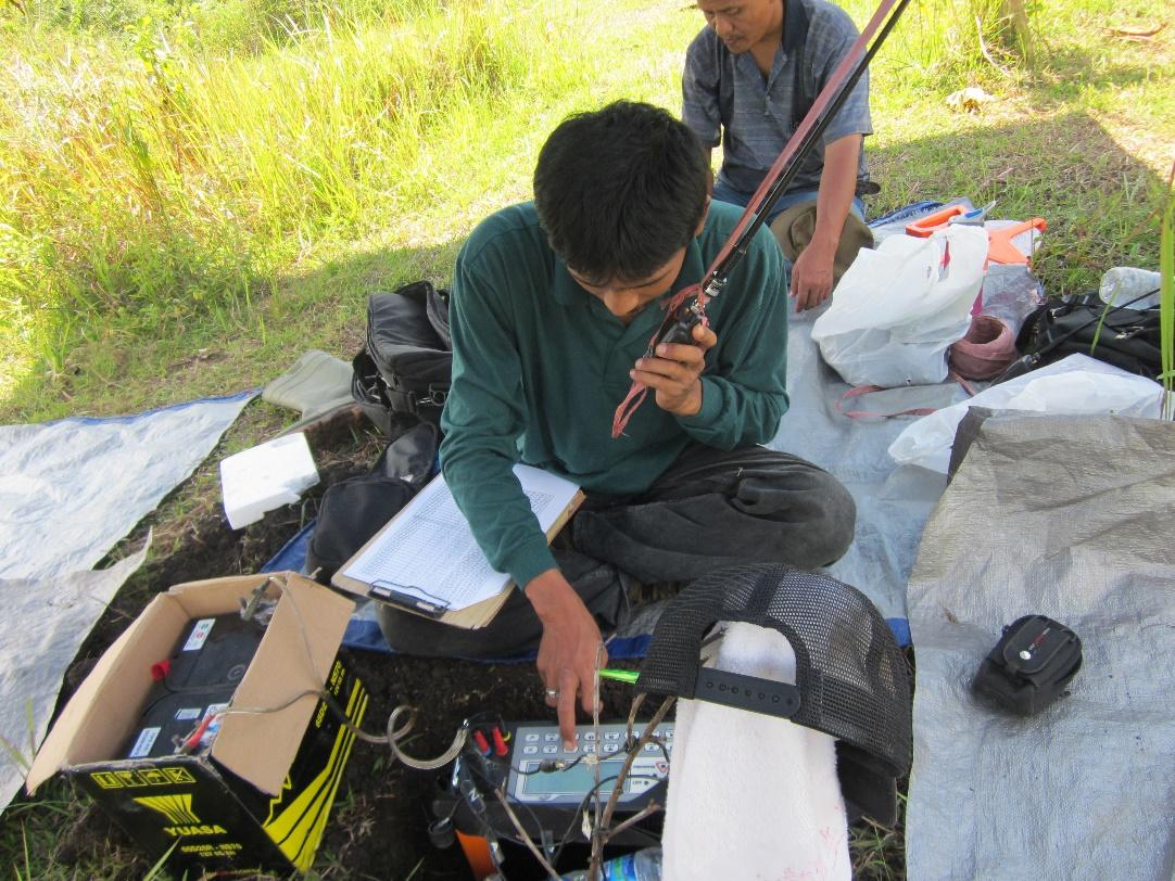 A person using a phone while sitting on the ground

Description automatically generated