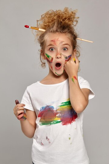 A child covered in paint and making a guilty expression.