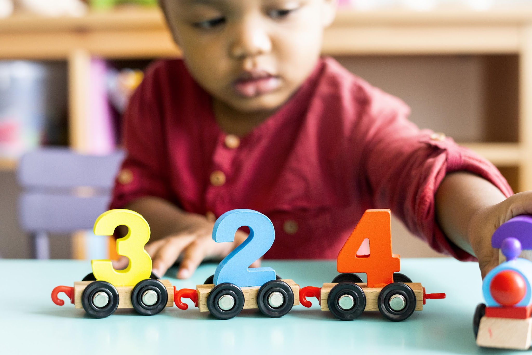 Little boy playing with number cars