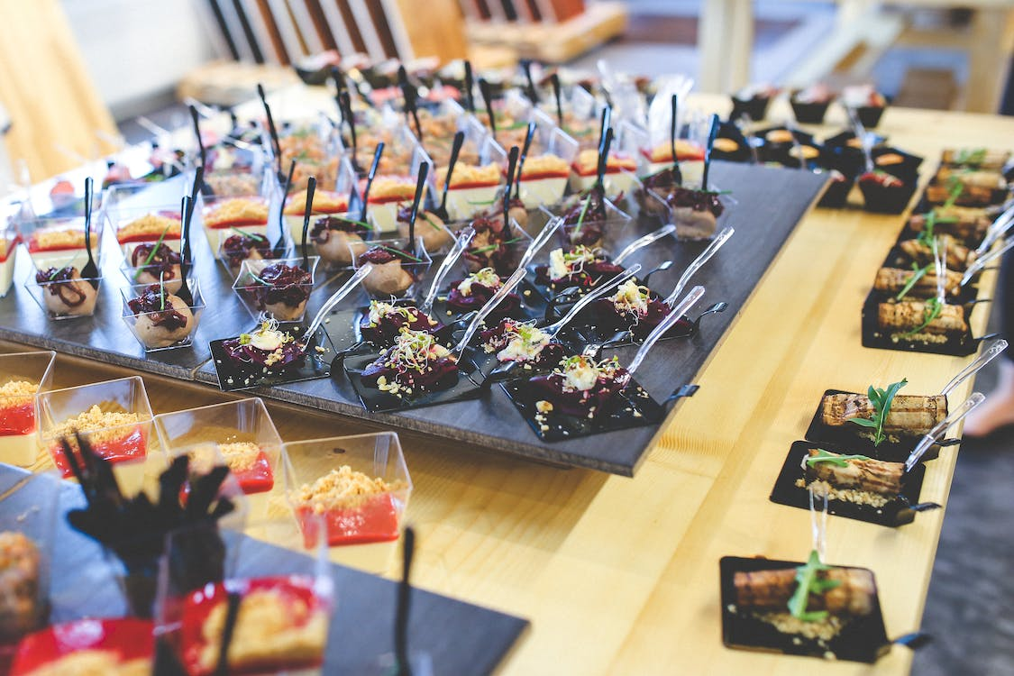 A close up of FlavorFulz edible spoons being used at a catering event.