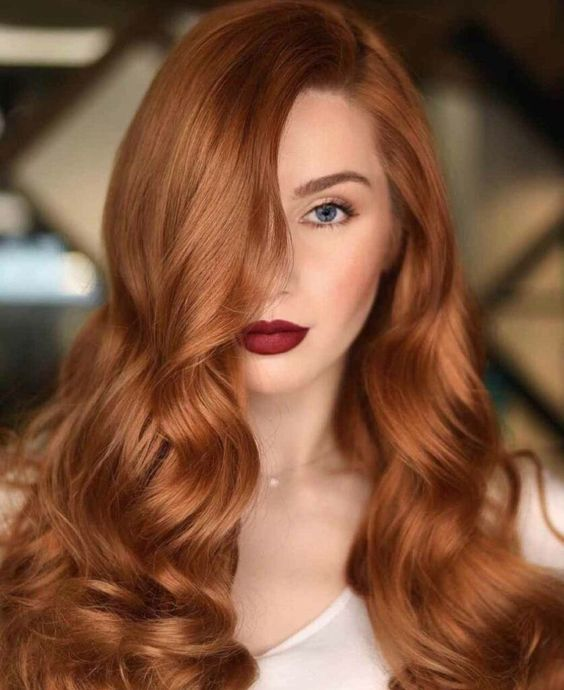 Picture showing a lady rocking the hair shade in a bouncy waves 