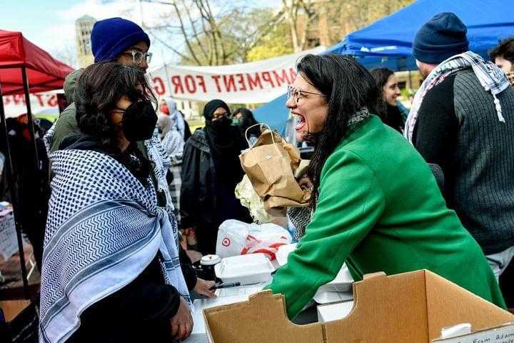 Rashida speaks to protestors at a mutual aid table.