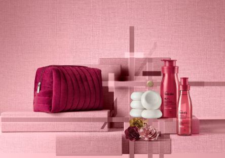 A group of cosmetics on a pink background

Description automatically generated