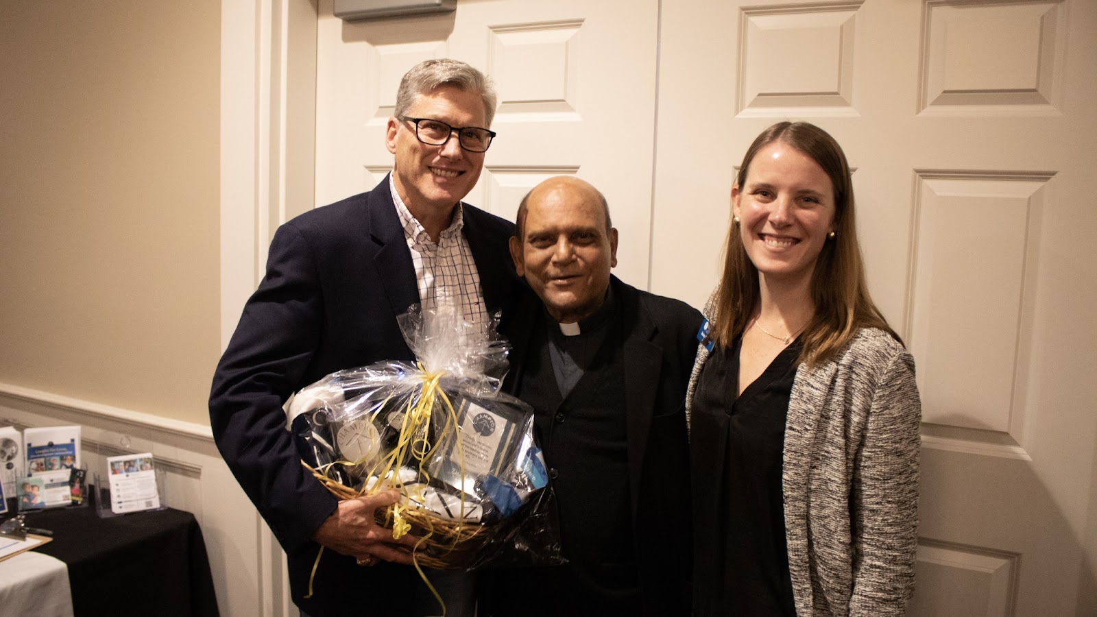 Dan (left) is honored with a MSC Champions basket with Msgr. Gregory and Executive Director of MSC USA, Betsy Fountain.