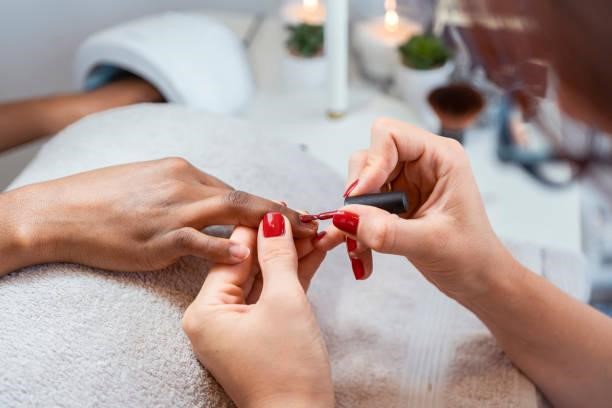Close up of female hands having manicure treatment Close up of female hands having manicure treatment at beauty salon doing manicure stock pictures, royalty-free photos & images
